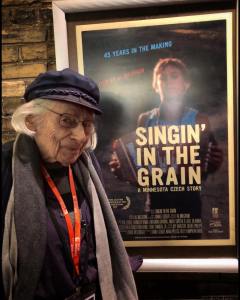 Al Milgrom poses with a poster for Singin' in the Grain