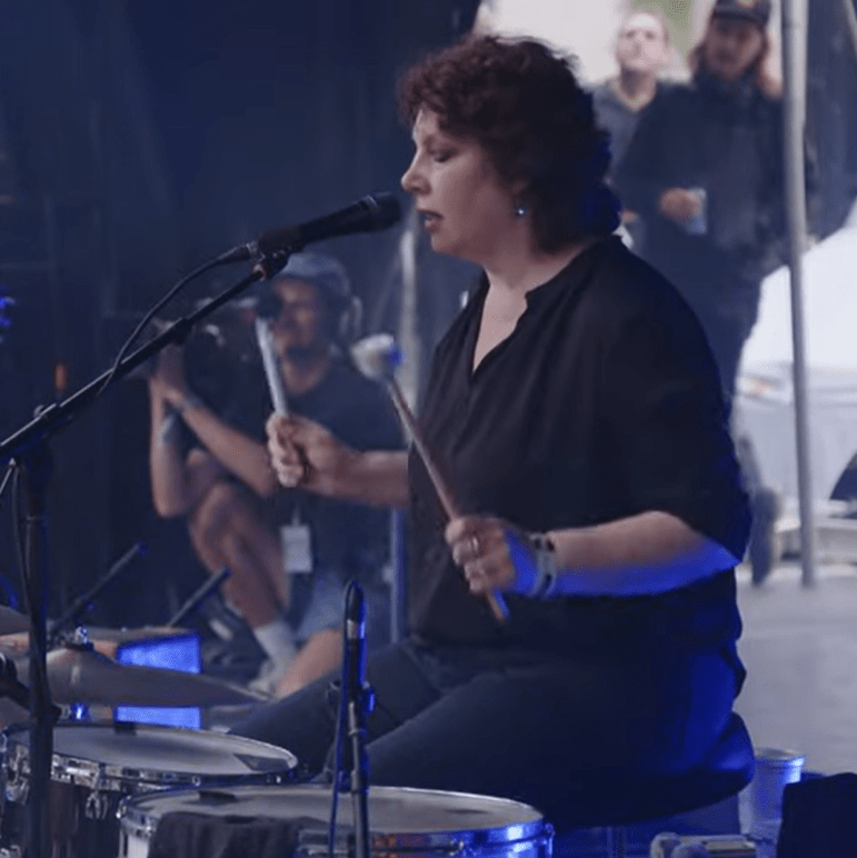 Mimi Parker playing drums and singing